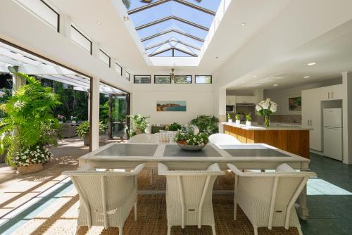 an open living room with a table and chairs at Emerald Inn on Takapuna Beach in Auckland