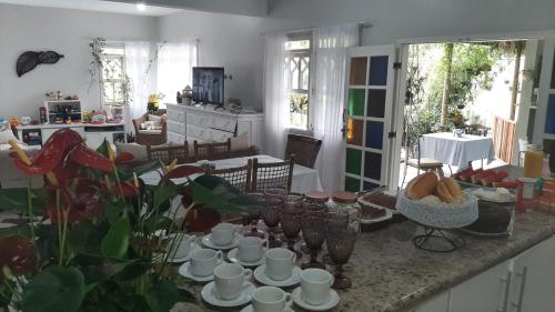 een keuken met een tafel met kopjes en borden erop bij Pousada Tartaruga Marinha in Ubatuba