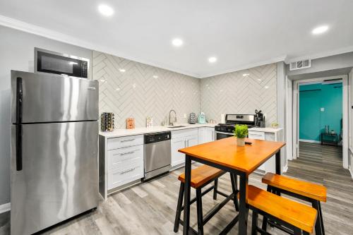 a kitchen with a stainless steel refrigerator and a wooden table at Quirky & Chic 1BR Near Montrose & River Oaks! in Houston
