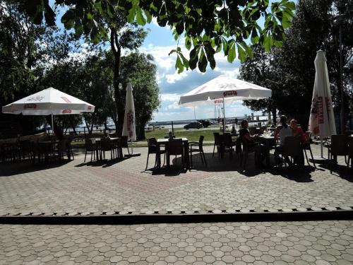a group of people sitting at tables under umbrellas at Holiday Home in Stepnica near Szczecin Lagoon in Stepnica