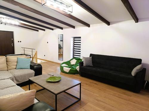a living room with a black couch and a table at Holiday Home in Stepnica near Szczecin Lagoon in Stepnica
