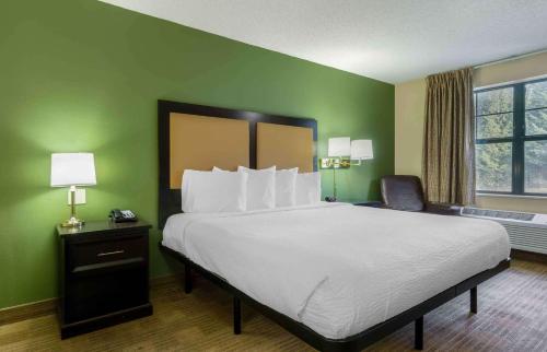 a large bed in a room with green walls at Extended Stay America Suites - Olympia - Tumwater in Tumwater