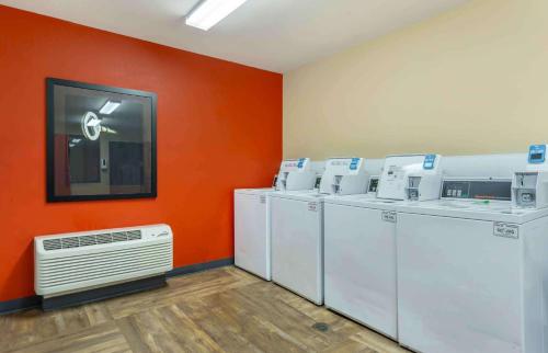 a laundry room with white washing machines and an orange wall at Extended Stay America Suites - Olympia - Tumwater in Tumwater