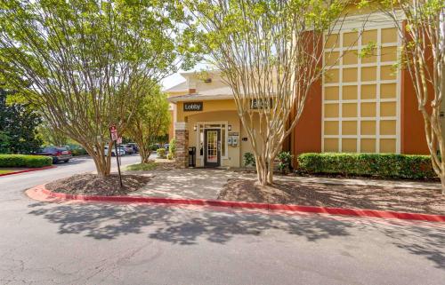 a building with trees in front of a street at Extended Stay America Select Suites - Atlanta - Cumberland Mall in Atlanta
