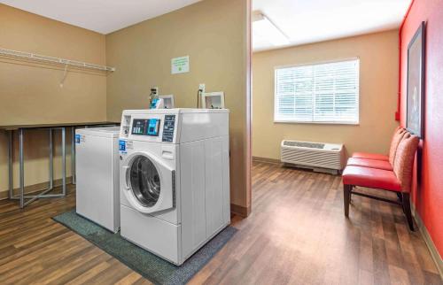 a laundry room with a washing machine and a chair at Extended Stay America Suites - Philadelphia - Malvern - Swedesford Rd in Malvern
