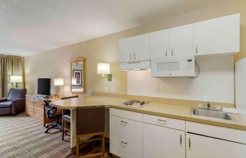 a kitchen with white cabinets and a table in a room at Extended Stay America Suites - Memphis - Germantown in Memphis