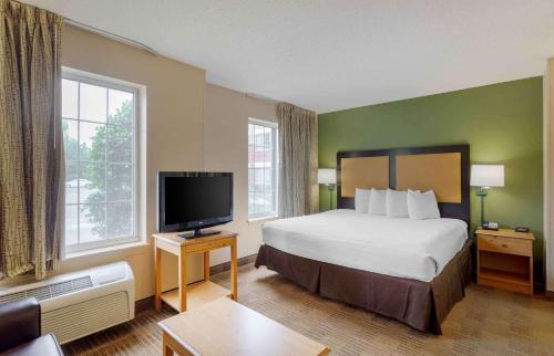 a hotel room with a bed and a flat screen tv at Extended Stay America Suites - Memphis - Germantown in Memphis