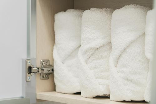 a pile of towels sitting on a shelf in a bathroom at 잠실Cozy BnB 가족친구여행 감성숙소 역세권 선착순 무료주차 #롯데타워 #KSPO #석촌호수 #서울아산병원 in Seoul
