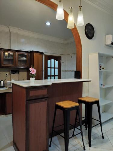 a kitchen with a counter and two stools at Spacious Bungalow with Large Outdoor in Sabah in Penampang