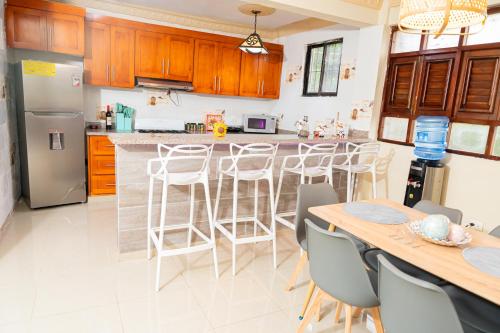 a kitchen with a counter and a bar with stools at Rancho Juliana in Villas del Mar