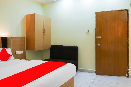 a bedroom with a bed and a cabinet and a door at Collection O Sri Subhamastu Grand in Vijayawada