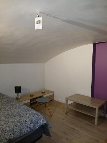- une chambre avec un lit, un bureau et un plafond dans l'établissement Appartement plein pied, à Dijon