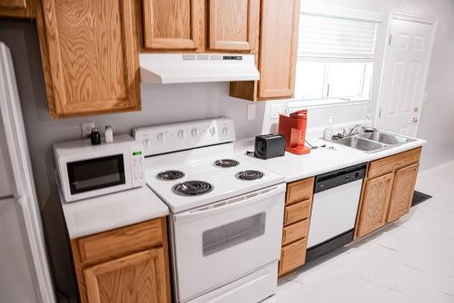 a kitchen with white appliances and wooden cabinets at Enchanting Garden with Luxe Jacuzzi Spacious Yard in Las Vegas
