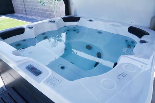 a bath tub sitting in a room with at Enchanting Garden with Luxe Jacuzzi Spacious Yard in Las Vegas