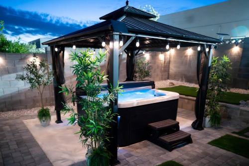 a hot tub in a gazebo with lights at Enchanting Garden with Luxe Jacuzzi Spacious Yard in Las Vegas