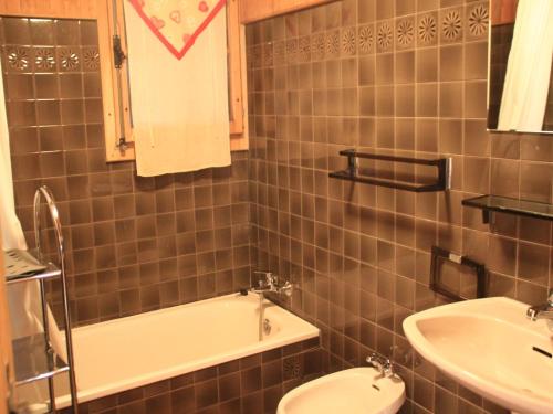 a bathroom with a sink and a tub and a toilet at Chalet in Vonnes near Chairlifts & Shuttle in Châtel