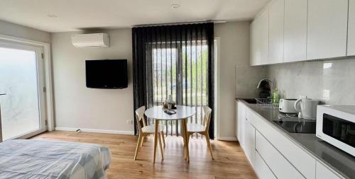 a room with a kitchen and a table and a bed at Cozy & Lux 1 Bed Studio Retreat in Weston Creek