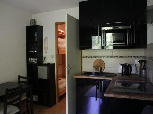 une cuisine avec des armoires noires et un comptoir dans l'établissement Apartment in Châtel near Barbossine Lift, à Châtel