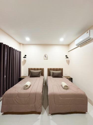 a bedroom with two beds in a room at jj home resort in Phun Phin