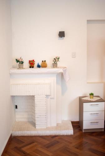 a white fireplace with three plants on top of it at Gutierrez Hostel in Lima