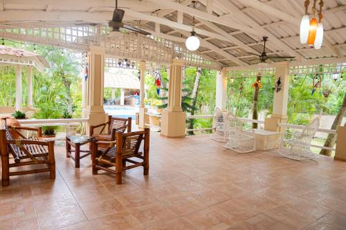 a large room with chairs and tables and windows at Rancho Juliana in Villas del Mar