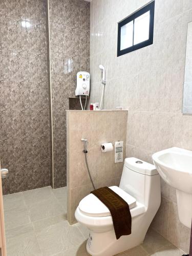 a bathroom with a toilet and a sink at jj home resort in Phun Phin