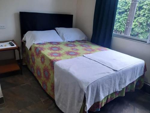 a bedroom with a bed and a window at Hotel escorpion in Melgar