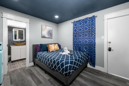 a bedroom with a bed with a blue comforter at Cozy Studio Escape Near Montrose in Houston