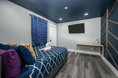a bedroom with a bed and a tv on a wall at Cozy Studio Escape Near Montrose in Houston