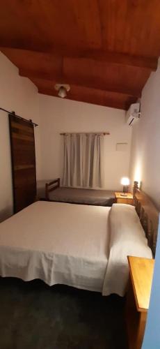 a bedroom with a white bed and a window at Cabañas Juca in Puerto Iguazú