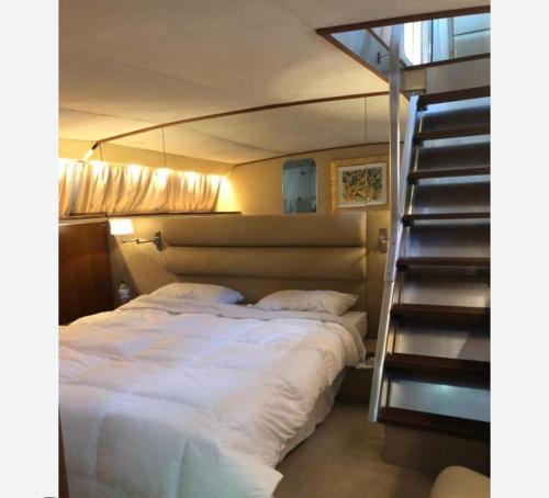 a bed with white sheets and a staircase in a room at Johnny M Yacht Private in Il-Gżira