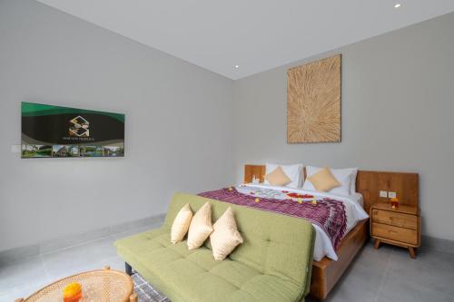 Un dormitorio con una cama y un sofá verde. en The Garden Villas, en Ubud