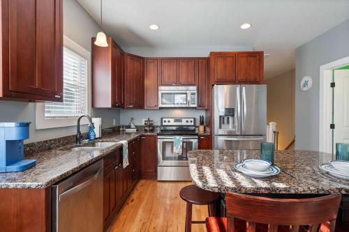 a kitchen with wooden cabinets and stainless steel appliances at Turtle Cove Beach Retreat GOLF CART Included in Carolina Beach