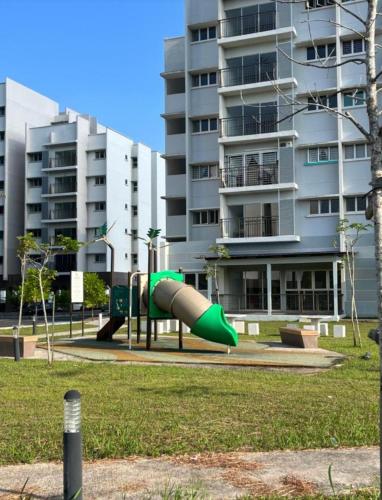 a green slide in a park in front of a building at Homestay Zailin A'Famosa in Kampong Pulau Sebang