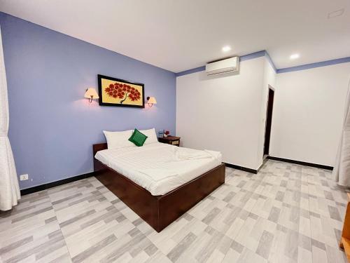 カンポットにあるKampot Orkide Guesthouseの青い壁のベッドルーム1室(ベッド1台付)