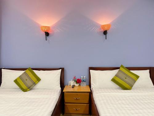 カンポットにあるKampot Orkide Guesthouseのランプ2つが付いた部屋のベッド2台