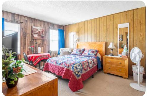 a bedroom with a bed and a dresser and a television at Happy Rest Stop House in North Fort Myers