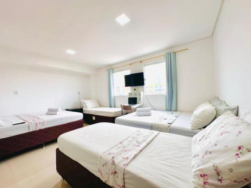 a hotel room with two beds and a couch at Suíte Estrela-do-Mar 2 - Pé na Areia in Maragogi