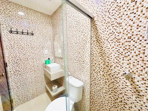 a bathroom with a toilet and a glass shower at Suíte Estrela-do-Mar 2 - Pé na Areia in Maragogi