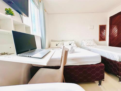 a laptop computer sitting on a desk in a room at Suíte Estrela-do-Mar 2 - Pé na Areia in Maragogi