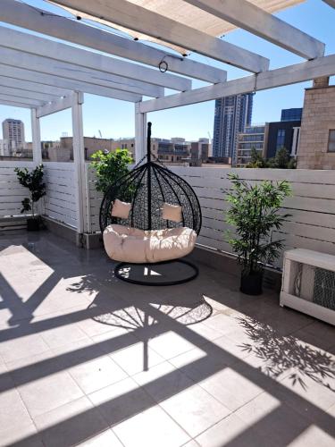a patio with a swing on a roof at Havatselet 19 By Isrentals in Jerusalem