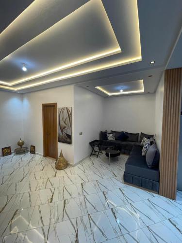 a living room with a blue couch and a marble floor at maison cotiére in Iterkine