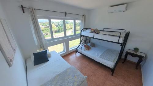 a bedroom with two bunk beds and a window at Beach House in Tela with a Pool in Tela