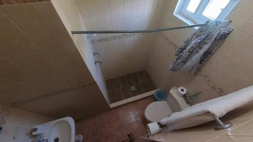 a bathroom with a shower and a toilet and a sink at Beach House in Tela with a Pool in Tela