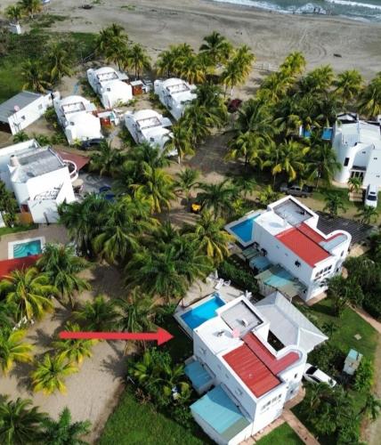 an aerial view of a group of houses and palm trees at Beach House in Tela with a Pool in Tela