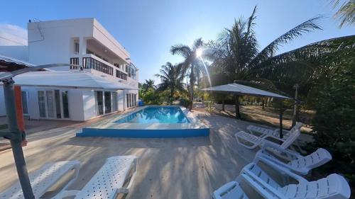 a swimming pool with lounge chairs and a house at Beach House in Tela with a Pool in Tela