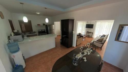 a living room with a table and a kitchen at Beach House in Tela with a Pool in Tela