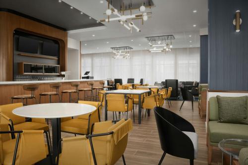 ピッツバーグにあるCourtyard by Marriott Antioch Pittsburgのテーブルと椅子とバーのあるレストラン