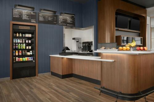 ピッツバーグにあるCourtyard by Marriott Antioch Pittsburgのカウンターと冷蔵庫のあるキッチン