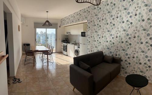 ラプラタにあるDepartamento moderno y luminoso en LA PLATAのソファとテーブルとキッチンのあるリビングルーム